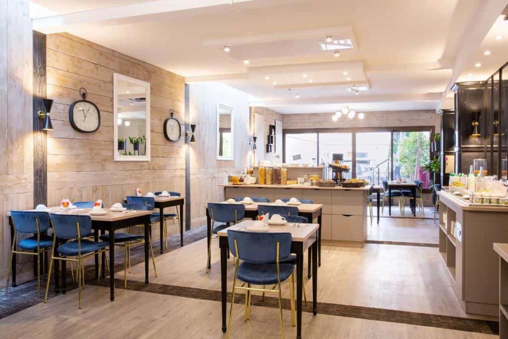 Breakfast dining area with wood panel walls, blue velvet chairs, and buffet setup at Best Western Plus L'Artist Hôtel.