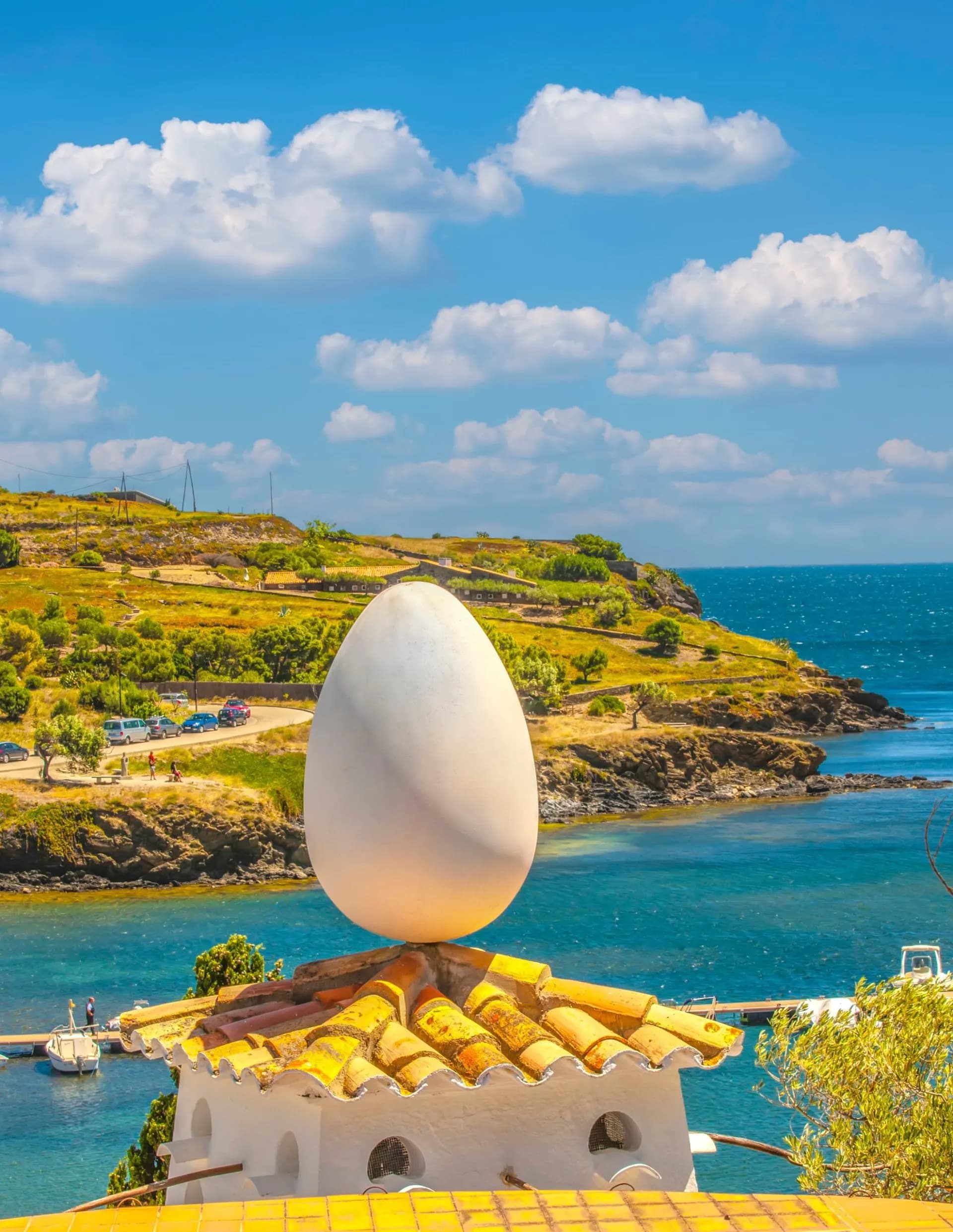 Giant egg sculpture atop a tiled roof overlooking the sea at Salvador Dalí's House.