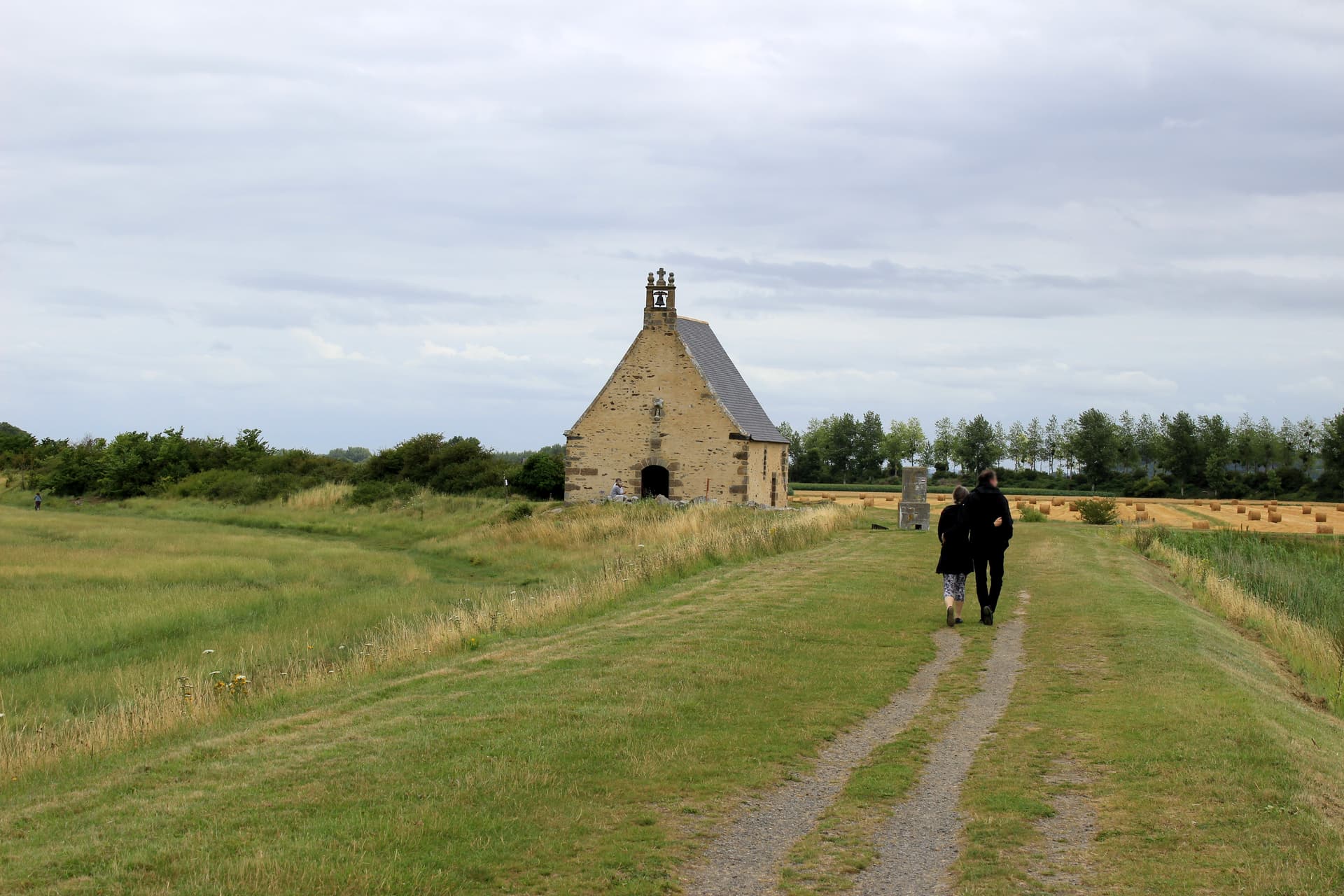 Chapelle Sainte-Anne-de-la-Grève near Saint-Broladre, stone chapel in field with hay bales.
