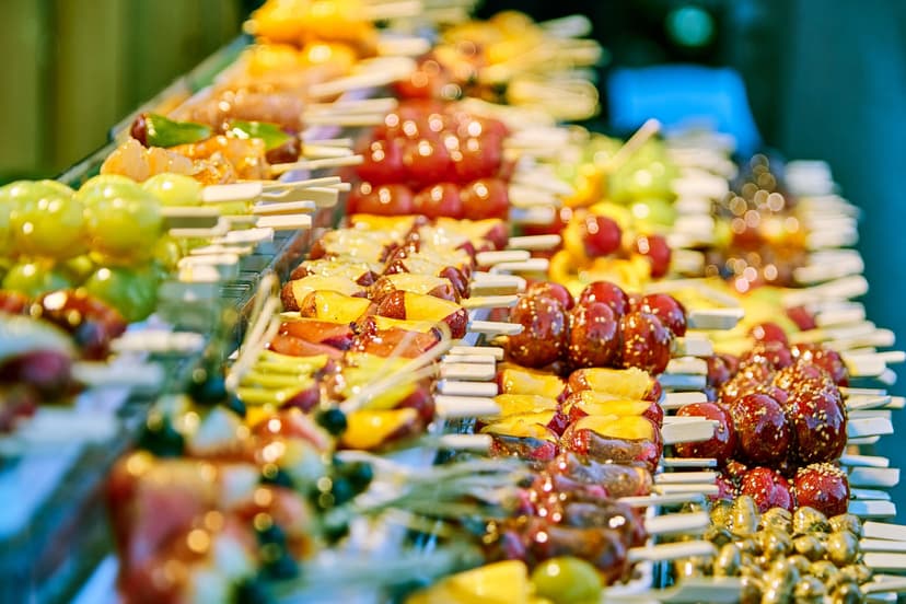 Candied fruit skewers on wooden sticks displayed at a market stall