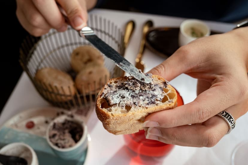 Spreading tapenade on a slice of bread with a knife