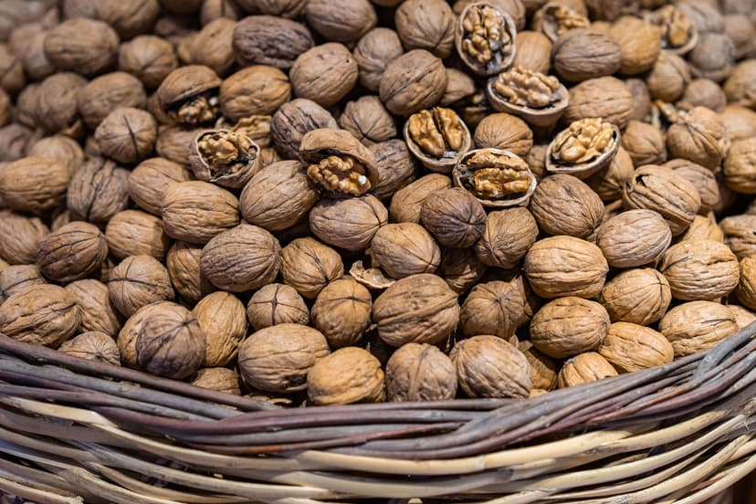 Wicker basket filled with whole and cracked walnuts