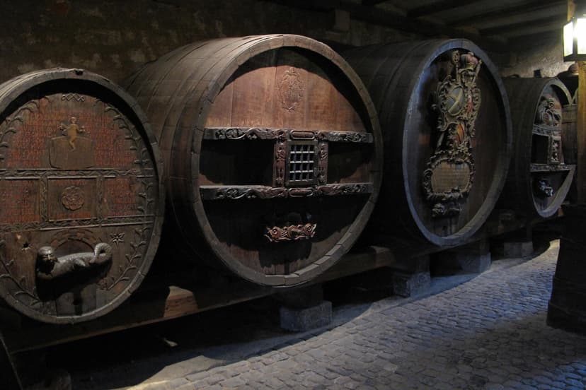 Large wooden wine casks with ornate carvings in a historic cellar at Unterlinden in Alsace